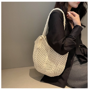 Detail of off-white woven tote bag with fringe charm and handmade mesh design