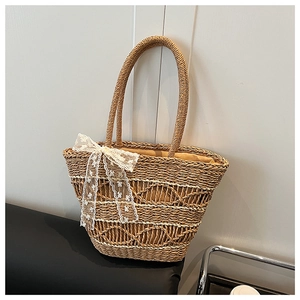 Detailed texture of handwoven straw tote bag with elegant white lace bow decoration