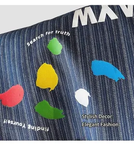 Detail of blue striped denim tote with colorful paint splash print and text design