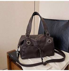 Detail of dark brown faux leather tote with metal ring and drawstring pocket design