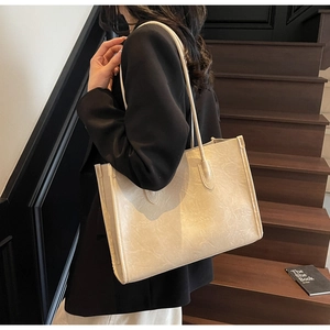 Detailed view of beige vintage textured PU leather tote bag worn on shoulder for commuting