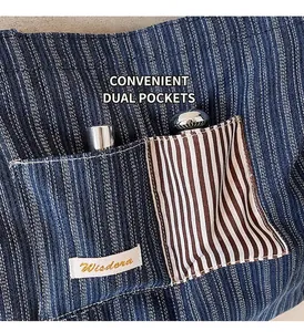Detail of denim tote bag showing dual patch pockets with blue and white stripes