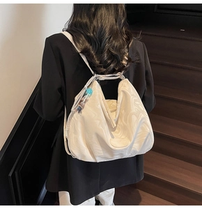 Detail of white marble print tote bag featuring cloud pleated design and logo patch