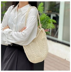 Détail du sac cabas en crochet crème avec motif à mailles évidées et frange à glands chic
