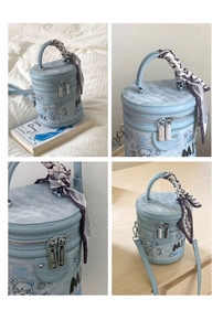 Dettaglio della borsa a secchiello azzurra con graffiti di orsi e foulard