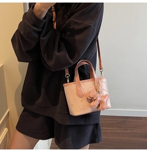 Mini sac seau rose avec breloque chien 3D et gaufrage ours porté par le mannequin