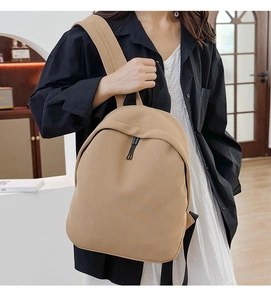 Detail of khaki oxford fabric backpack with wide shoulder straps shown on model