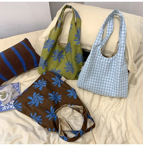 Detailed view of three nylon crescent bags with floral and checkered print designs