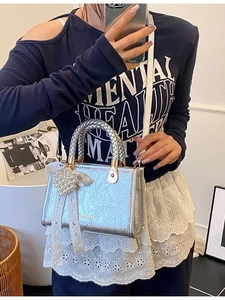 Metallic silver pleated handbag with woven handle and large pearl lace bow charm