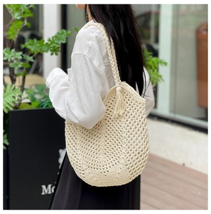 Détail du cabas en crochet crème fait main avec anses tressées et décoration de pompon