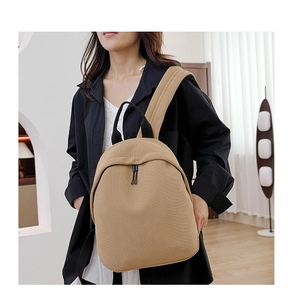 Detail view of khaki Oxford cloth backpack on a model showing daily wear style