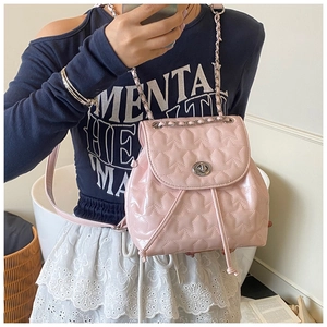 Quilted pink backpack with star stitching and silver chain strap shown on a model