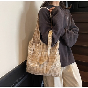 Detail of yellow checkered canvas tote bag with white lace trim for shoulder wear