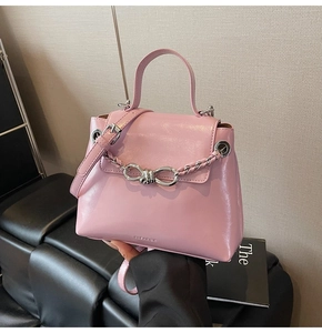 Detail of pink leather handbag with silver bow chain and fine shoulder strap detail