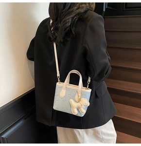 Détail du sac seau bleu clair avec imprimés animaux mignons et charm de chien 3D inclus