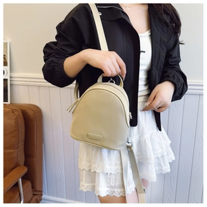 Close-up of beige mini backpack with CAHEKA brand plaque and textile shoulder straps