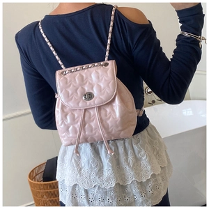 Detail of light pink mini backpack with star quilting, silver twist lock and chain strap