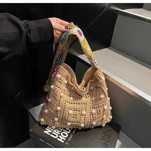 Detail der beige Häkeltasche mit weißen Perlen und buntem Blumen-Gurtband