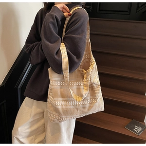 Detail view of the yellow gingham canvas tote bag with white geometric stripe patterns