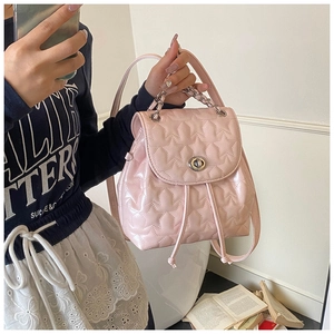 Detail of pink mini backpack with star quilting, silver twist lock and woven chain handle