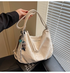 Detail view of large white marble texture tote bag with cute puppy plush keychain accessory