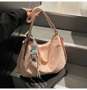 Detailed view of pink marble texture tote bag with a cute bear charm on leather straps