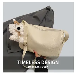 Detail showing off-white pebbled leather handbag with cute teddy bear bag charm