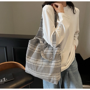Detail of black and white gingham canvas tote bag with white jacquard stripe accents