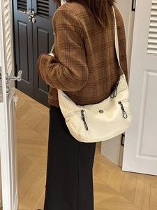 Sac demi-lune beige minimaliste avec tirette tissée pour un porté décontracté