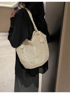 Sac bandoulière tissé ajouré blanc cassé avec pampilles, porté sur l'épaule de côté