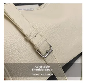 Detail of beige lychee grain leather bag showing silver metal adjustable buckle strap