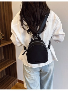 Mini black nylon backpack for women shown from a high-angle back view on a model