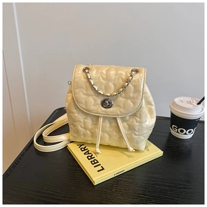 Macro view of cream quilted star pattern on leather backpack with silver twist lock