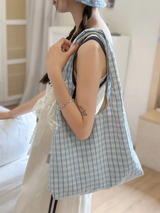 Blue and white plaid nylon crescent hobo bag with matching bucket hat on model