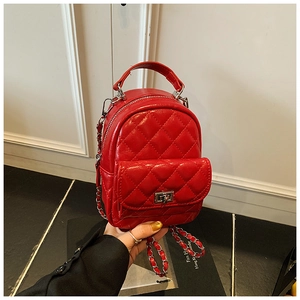 Macro shot of red quilted mini backpack featuring metallic chain strap and silver twist lock