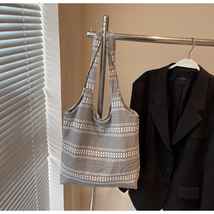Detail of woven black and white tote bag texture hanging on a metal rack