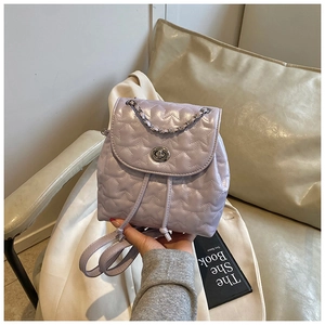 Close-up of lilac mini backpack with star quilting, silver twist lock and chain handle