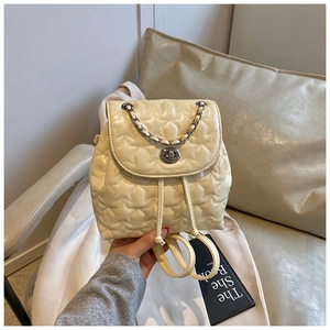 Detail of star-quilted cream leather backpack with silver chain and turn-lock closure