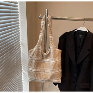 Detail of brown gingham canvas tote bag with woven stripes and natural fabric texture