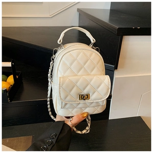 Close-up of quilted cream mini backpack featuring a gold turn-lock and chain strap