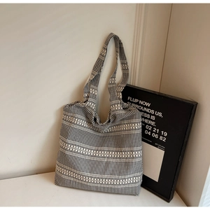 Detail of black and white checkered woven tote bag showing soft texture and large capacity
