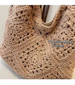 Gros plan du sac bandoulière tissé marron montrant le détail du motif évidé fait main