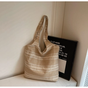 Detail of minimalist brown gingham tote bag featuring white geometric embroidery patterns
