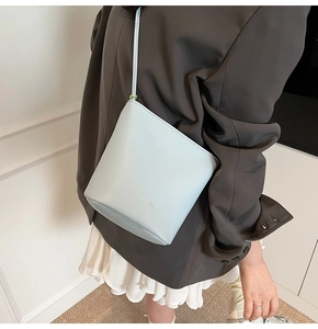 Close-up of light blue bucket bag with lychee grain texture and silver ELI & GIA logo