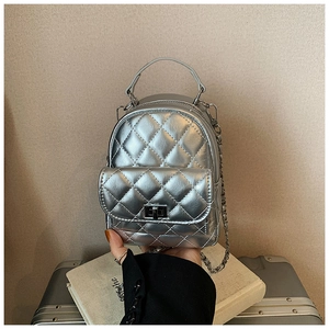 Detail of silver metallic quilted mini backpack with chain strap and metal turn-lock
