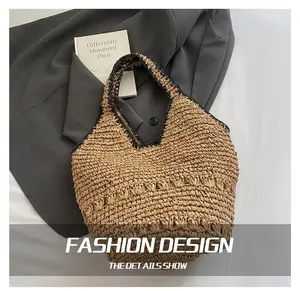 Detail view of handmade straw woven shoulder bag with intricate cutout patterns and black trim