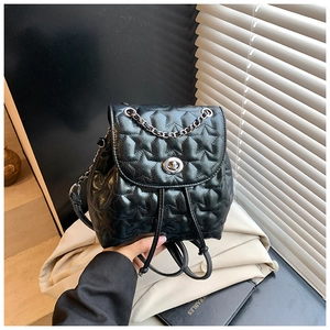 Close-up of star quilted leather backpack with silver turn-lock and chain strap