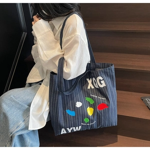 Detail of navy striped canvas tote bag with colorful abstract prints and long shoulder straps