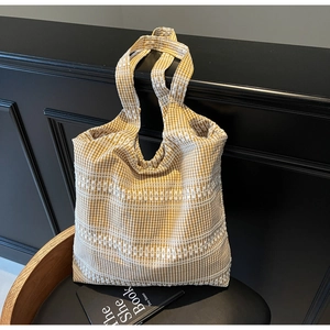 Detail of yellow and white plaid canvas tote bag with decorative white lace embroidery