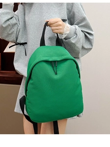 Minimalist green woven Oxford fabric backpack for women featuring stylish black zippers